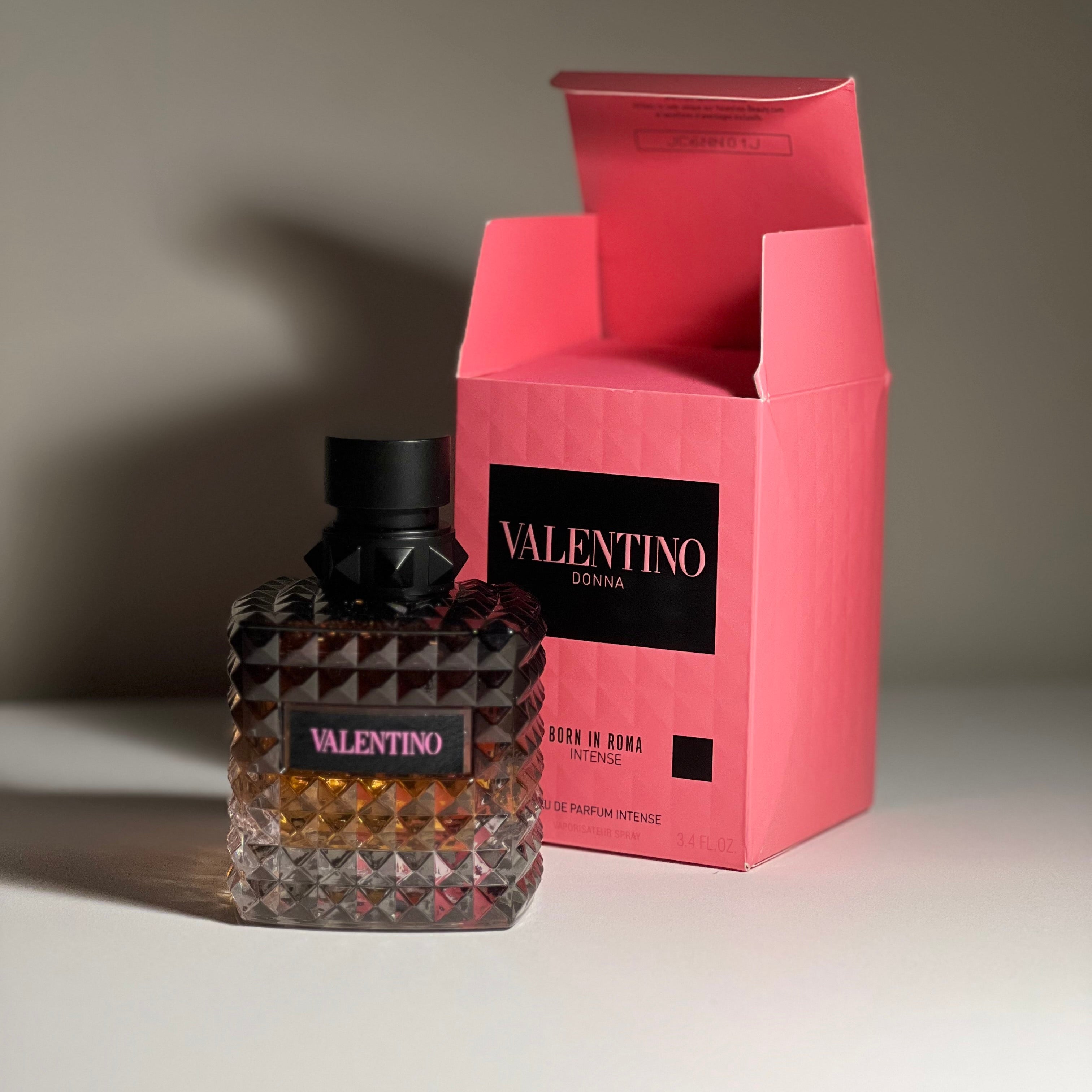 Valentino perfume bottle and packaging on a neutral background